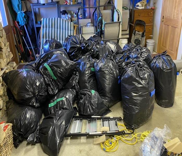 black plastic garbage bags piled up in a corner